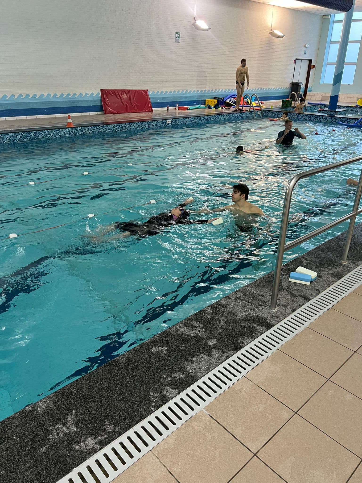 Groep zwemmers in actie tijdens zwemlles